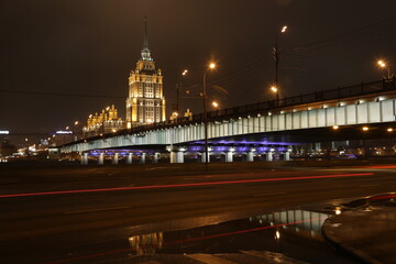 Fototapeta na wymiar night city Moscow, Russia. The bridge, the river and the Stalinist skyscraper were photographed at night using camera exposure