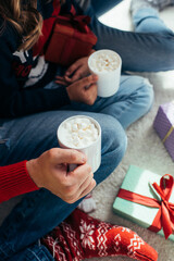 cropped view of man and woman holding cocoa with marshmallows in cups