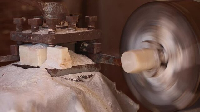 The processing of amber. Polishing and grinding pieces of amber. Making jewelry from the sun stone. Manufacturing technology amber products. Master grinds amber. Polishing wheel. Natural mineral.