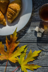 Still life with cup of coffee and fallen leaves and sweets