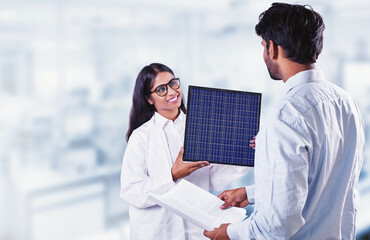 Two Indian scientists looking at solar battery