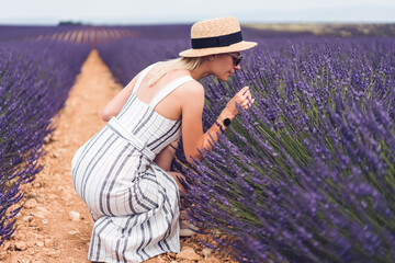 Female traveler smelling lavender flowers in field