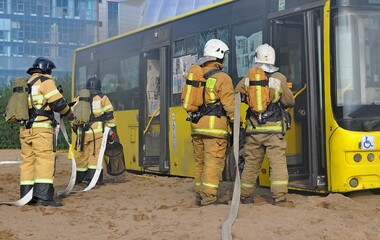 Firemen on exercises to extinguish a burning public transport bus