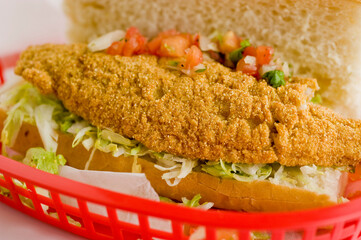 Fried fish or po boy sandwich. Classic Cajun cuisine: fried fish sandwich served on toasted bun w/onions, lettuce, tomato, mayo, salt & pepper. Classic New Orleans sandwich favorite.