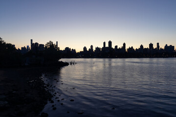 Fototapeta premium Silhouettes of Skyscrapers in the Upper East Side and Manhattan Skyline along the East River in New York City during the Evening