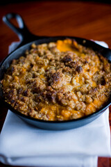 Sweet potatoes or candies yams with toasted marshmallows topped with cheese cream, garnished w/ scallions and Italian parsley & served in cast iron skillet . Classic American thanksgiving side dish.