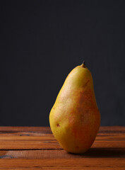 Yellow pear on boards and gray background