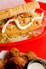 Fried fish or po boy sandwich. Classic Cajun cuisine: fried fish sandwich served on toasted bun w/onions, lettuce, tomato, mayo, salt & pepper. Classic New Orleans sandwich favorite.