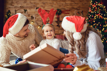 The family gives gifts to the child in the room in Christmas