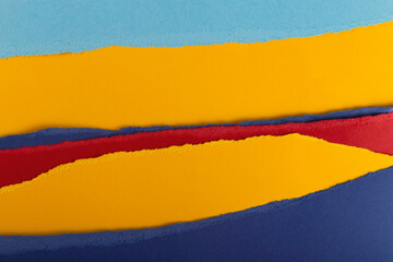 Texture of multi-colored torn paper in yellow, red and shades of blue. Background