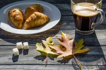 Still life with cup of coffee and fallen leaves and sweets