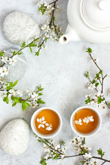 Fototapeta na wymiar Tea bowls and cherry flowers on light background