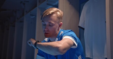 Technology for sport and active living. Soccer or football player man talking into smartwatch wearable tech device speaking to someone or dictating message on smart watch app. Fitness lifestyle.