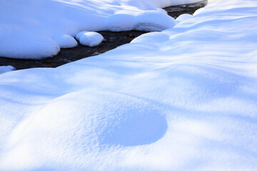 雪の造形と川面