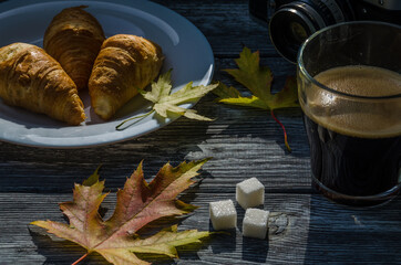 Still life with cup of coffee and fallen leaves and sweets