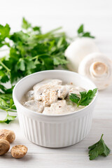 Mushroom cream sauce with nutmeg in white bowl. Close-up view