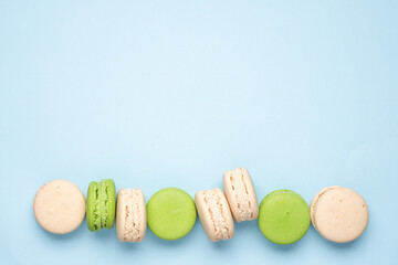 Traditional French macaroon pastry dessert on blue pastel background. Delicious morning breakfast