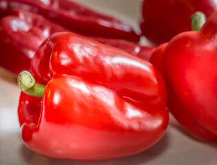 A close up picture of red bell and cubanelle peppers.