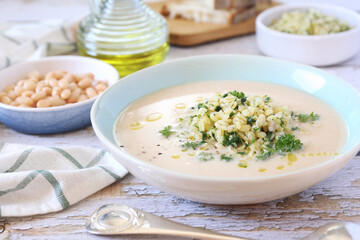 White bean vegetarian cream soup with fried pearl barley and parsley, bread and olive oil