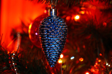 Christmas tree decoration in the form of a blue cone hanging on a branch of the Christmas tree. Christmas background with a Christmas tree toy "Cone" close-up.