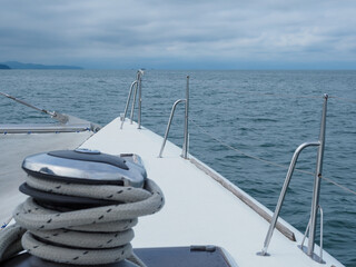 A view from a yacht deck seeing out through the ocean and cloudy sky.