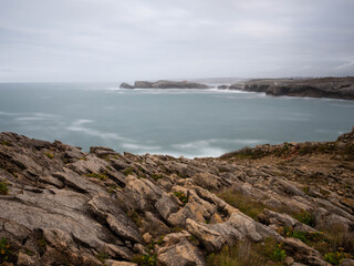 Fototapeta na wymiar View of the Isla de la Virgen del Mar from the beach of San Juan de la Canal. Seascape with rocks on a cloudy day on the Cantabrian coast