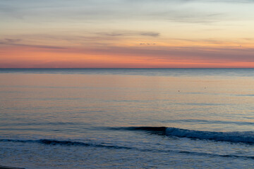 beautiful sunset over the ocean with colorful sky and small waves