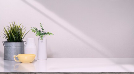 Mockup  decoration object with yellow cup, ceramic vase and houseplant on white top table, copy space.