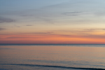 Obraz premium beautiful sunset over the ocean with colorful sky and small waves