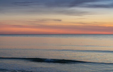Obraz premium beautiful sunset over the ocean with colorful sky and small waves