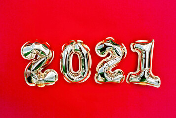Banner. Happy New year 2021 celebration. Gold  foil balloons numeral 2021 on red background. Flat...