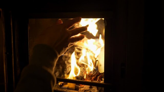 Close up woman lights fire in home fireplace. Winter time. Slow motion 4K