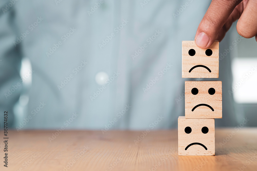 Poster select emotion or mood concept , hand holding and stacking sad face which print screen on wooden cub
