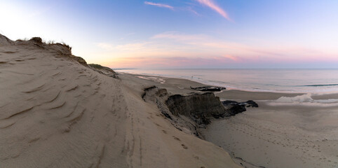 wild coast and ocean with large sand dunes at sunrise