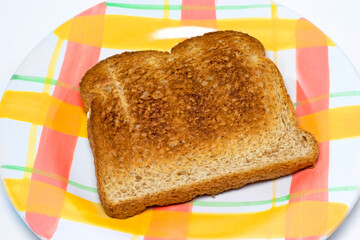 Plain and simple slice of wheat toast on a plate. 