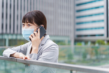 マスクをして電話をする若いビジネスウーマン