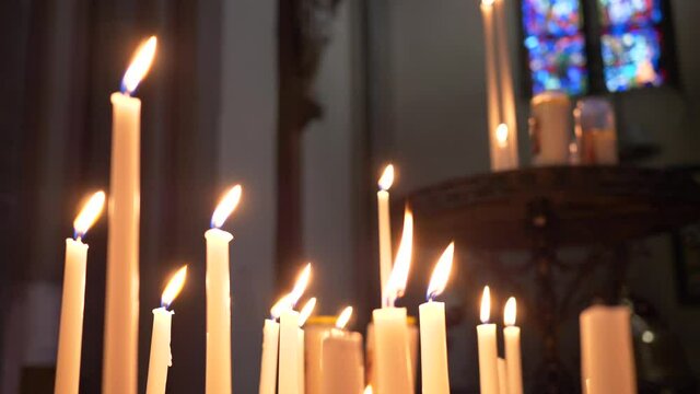Close up burning candles in a Christian church. Slow motion 4K
