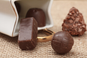 Chocolate candies various shape on sackcloth.