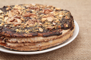 Chocolate cake on a plate on the sackcloth.