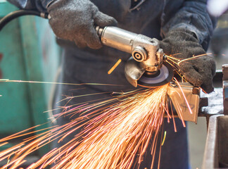 worker cutting steel with grinder