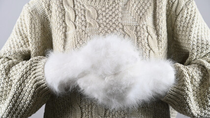 Girl holding gift wrapping in fluffy gloves