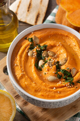 Pumpkin hummus and ingredients on wooden table	