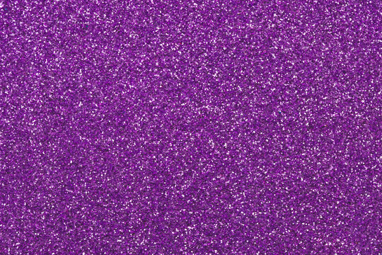 Purple sparkly fabric texture, Christmas paper backgrounds. Dark violet glitter surface. Abstract grain pattern. Festive decoration. Shiny sequins. Holiday art design with lights, shiny effect.
