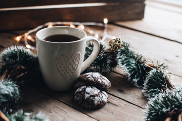 Christmas styled composition. Winter still life. Scandinavian hygge concept. Morning concept. Cozy winter scene with hot tea or coffee and cookies. Flat lay. Home decor.