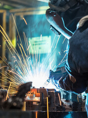 worker with protective mask welding metal.