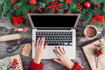 Female hands using laptop on Christmas wooden table background stock photo