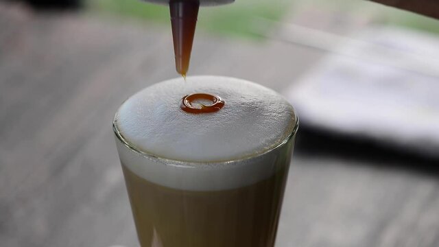 Coffee decoration.
Caramel art on milk foam of latte coffee ,hd video. 
