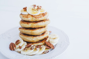 Stack of homemade small thick pancakes served with fresh blueberries.