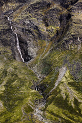 A delightful waterfall falls from the rock among the moss surrounding it