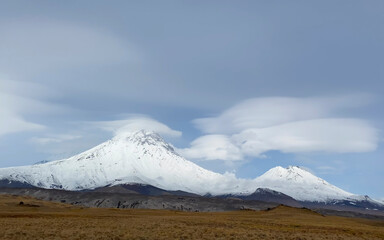 Fototapeta premium A magnificent view of the volcanoes of central Kamchatka. Picturesque mountains, hills and plains.